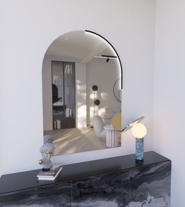 Image of a mirror on the wall above a living room piece of furniture with a light fixture illuminating it